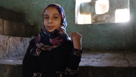 A young girl poses inside a building