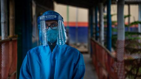 A health worker wearing a protective shield mask