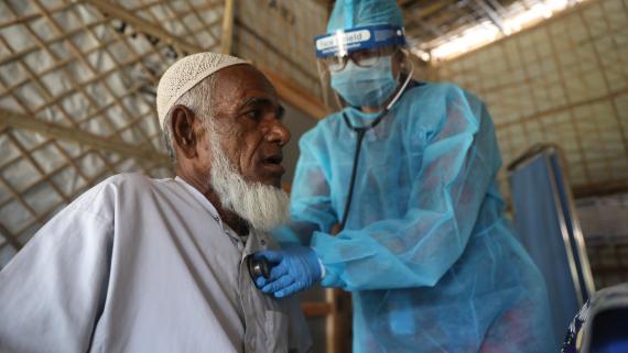 An old man is checked by a doctor