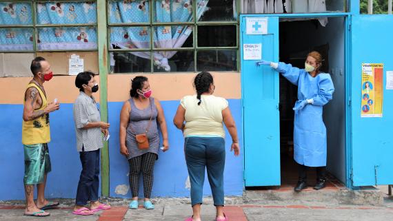 Doctor showing returnees in COVID-19 confinement in a temporary shelter to keep social distancing