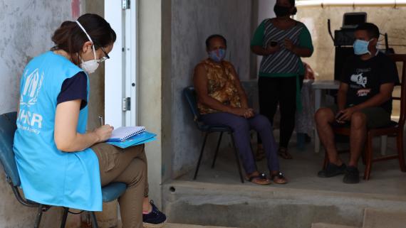 an aid worker interacts with community members and recent returnees