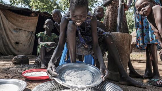 A refugee child prepares a meal