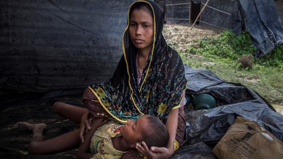 A refugee mother holds her sick son