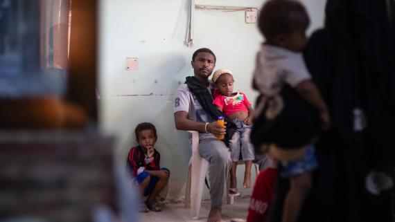 A father and his two children wait to be observed by a doctor