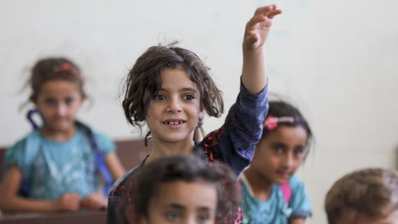 A scholar girl raises her hand