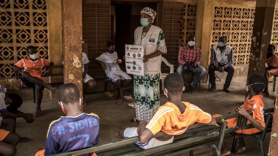 A nurse and social worker leads a sensitization/risk awareness session on COVID-19 at a temporary shelter 