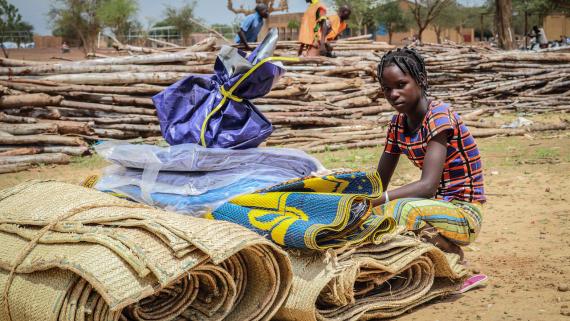 A girl sitting next to a shelter kit