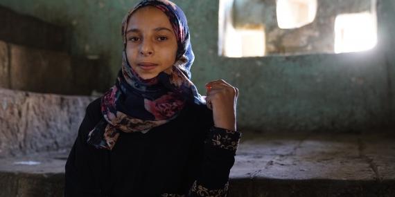 A young girl poses inside a building