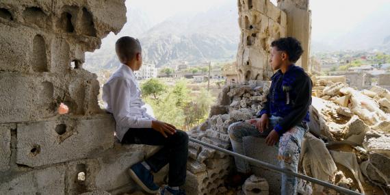 Two boys look out the top floor of their destroyed house